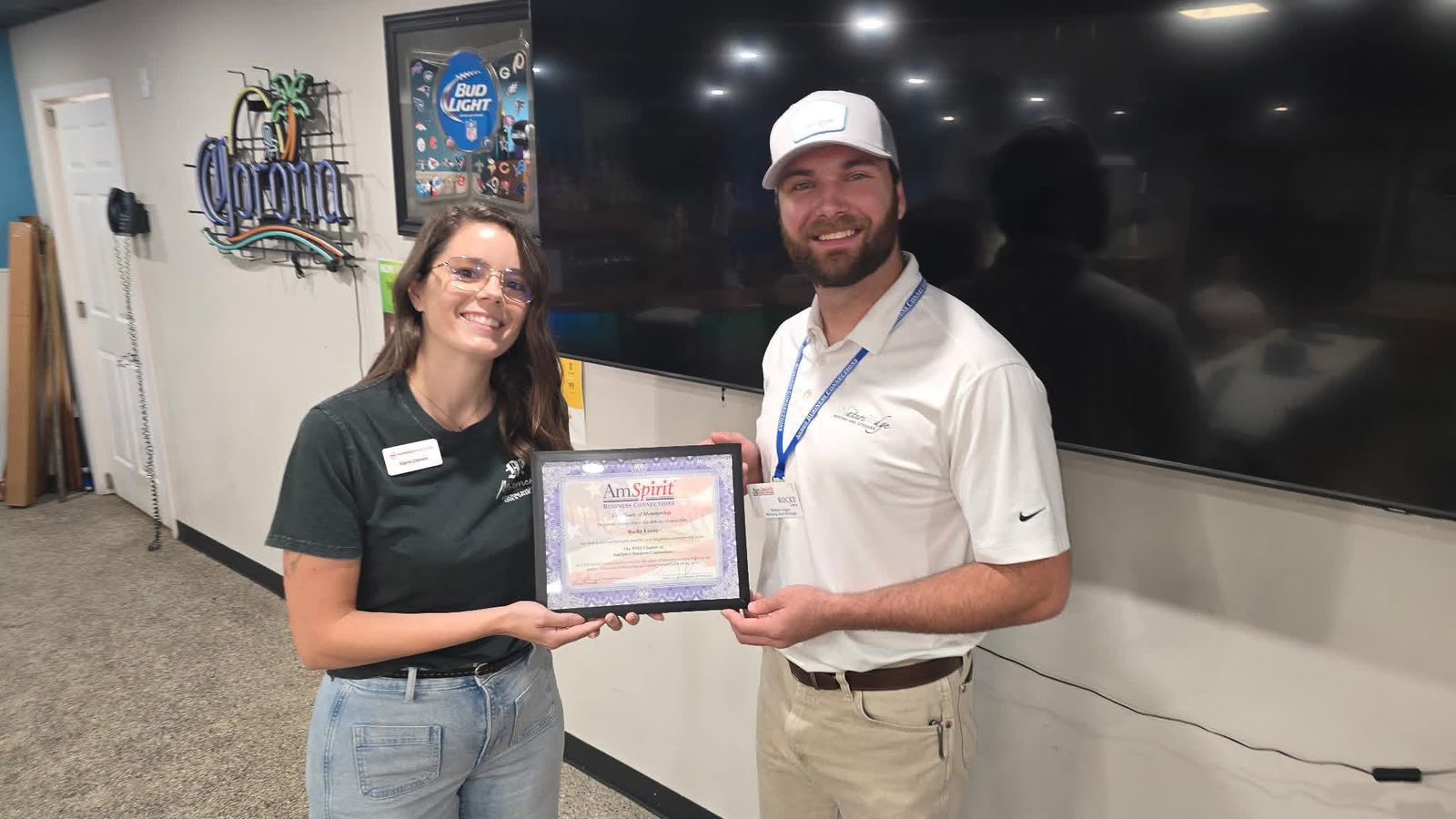 Two people holding a framed certificate together